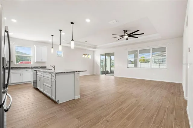 a living room with furniture kitchen view and a chandelier