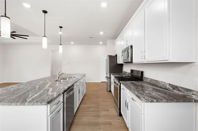 a view of a room with wooden floor and a ceiling fan