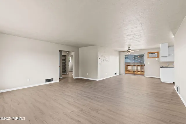 a view of empty room with wooden floor and window