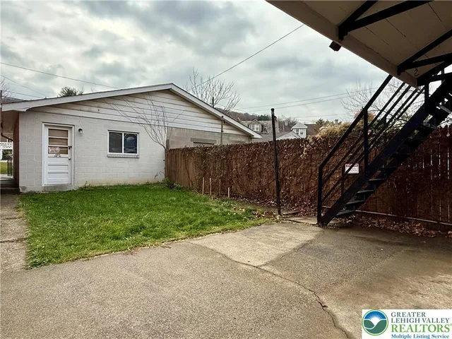 a view of backyard with potted plants and wooden fence
