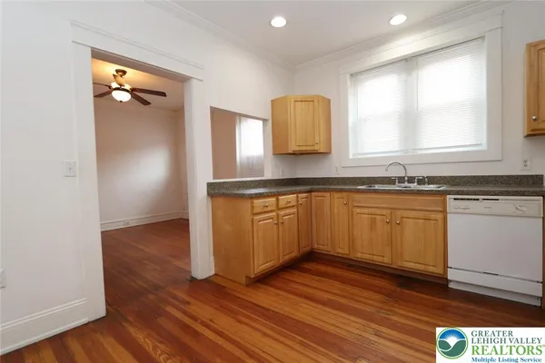 a kitchen with wooden floors and white cabinets
