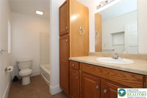 a bathroom with a granite countertop sink a toilet and a mirror