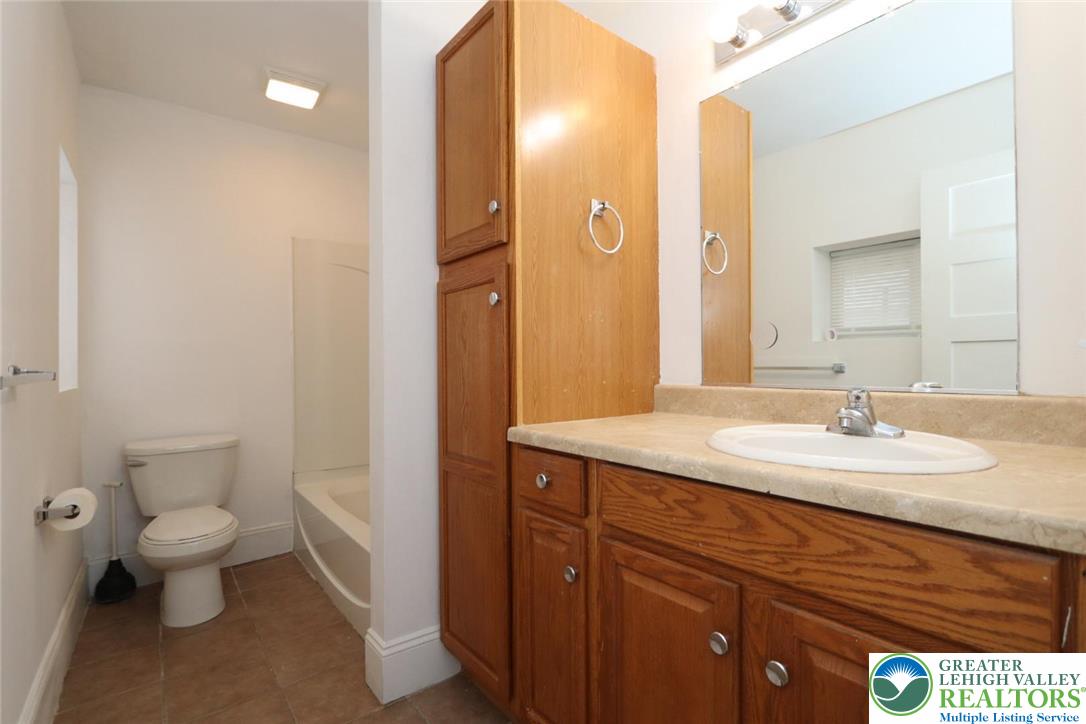 728 East 6th Street, Unit 1 Bethlehem, PA 18015 - Photo 10 of 15 a bathroom with a granite countertop sink a toilet and a mirror