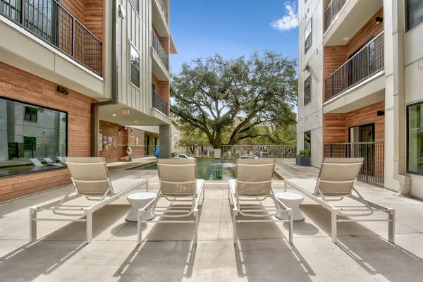 a view of a patio with couches table and chairs and potted plants