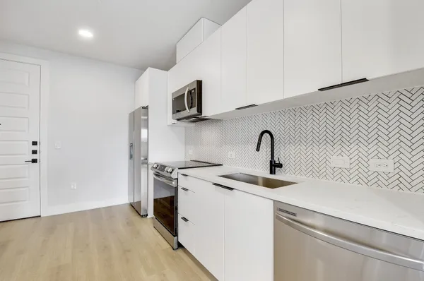 a kitchen with stainless steel appliances granite countertop a sink and a stove