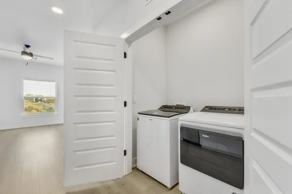 a view of kitchen with stove and white cabinets
