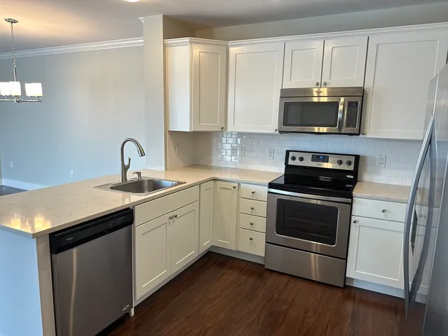 a kitchen with stainless steel appliances white cabinets and a sink