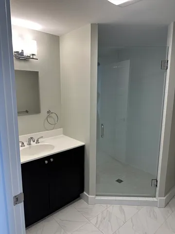 a bathroom with a sink a shower and a mirror