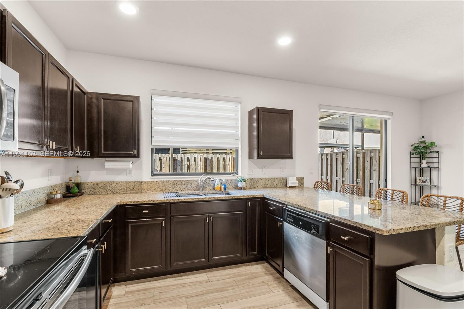 11429 Southwest 253rd Street Homestead, FL 33032 - Photo 12 of 30 a kitchen with a sink and wooden cabinets