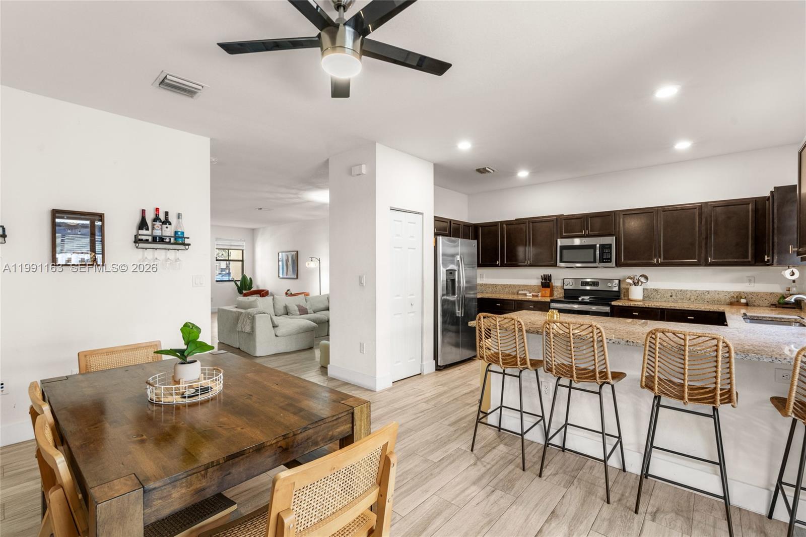 11429 Southwest 253rd Street Homestead, FL 33032 - Photo 13 of 30 a view of a dining room with furniture a kitchen and chandelier