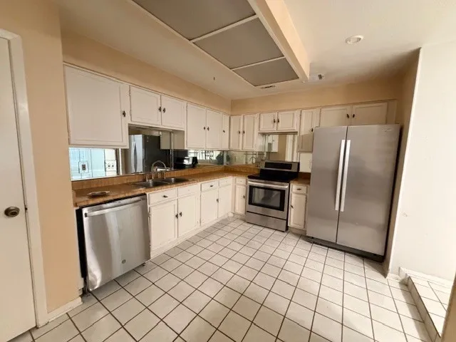 a kitchen with granite countertop white cabinets and white appliances