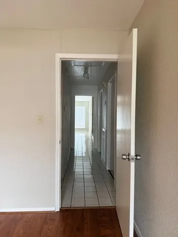 an empty room with wooden floor and a ceiling fan