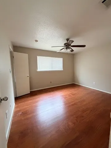 a view of a livingroom with wooden floor and a ceiling fan