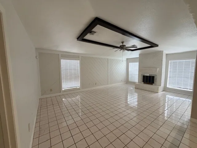 a view of empty room with wooden floor and fireplace