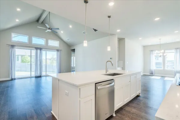 a kitchen with a sink chandelier and wooden floor