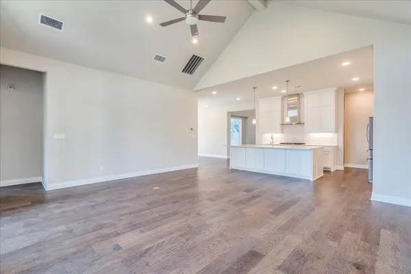 a view of an empty room and kitchen view