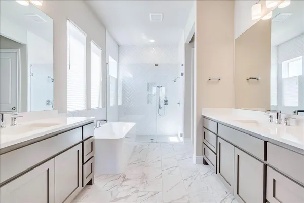 a spacious bathroom with a double vanity sink toilet mirror and bathtub