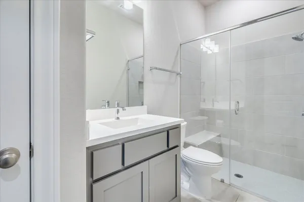 a bathroom with a sink toilet vanity and shower