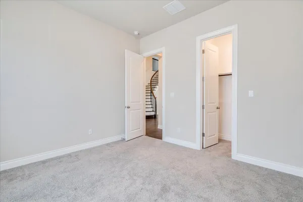 a view of an empty room with closet and entryway
