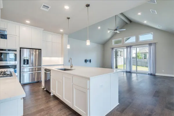 a large kitchen with stainless steel appliances kitchen island a large counter top and a view of living room
