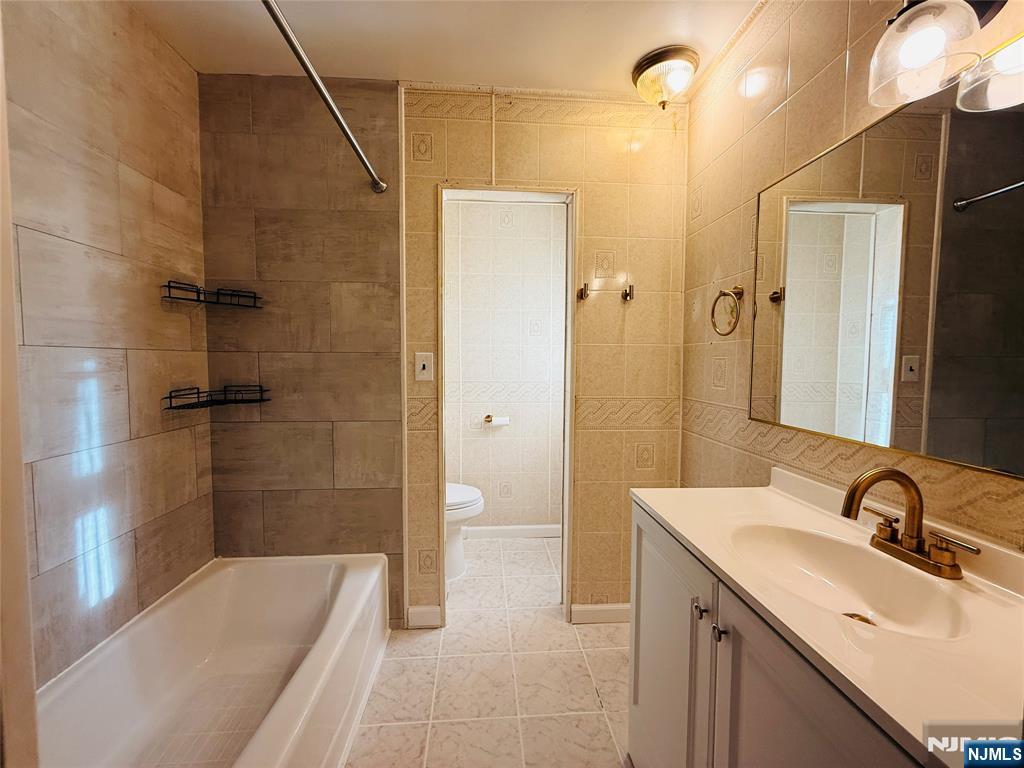 86 West Main Street, Unit FIRST Bergenfield, NJ 07621 - Photo 11 of 23 a bathroom with a sink a toilet and shower