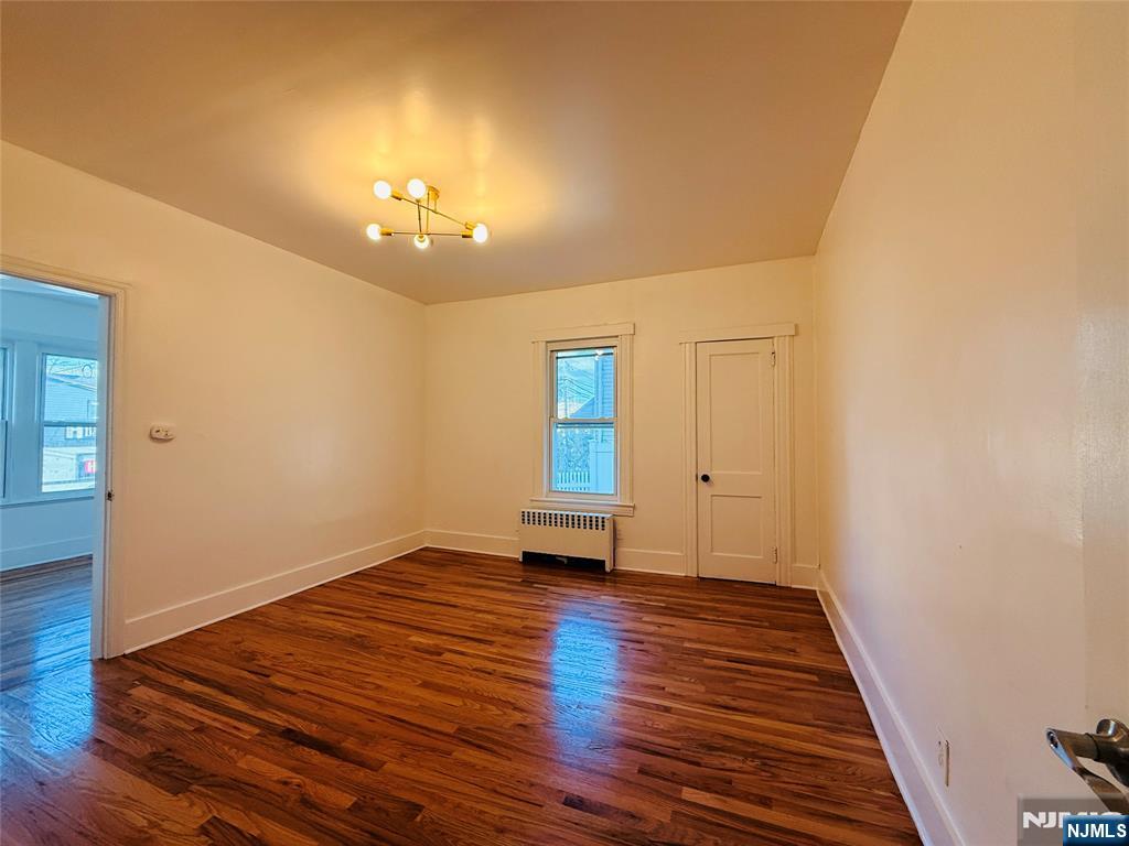 86 West Main Street, Unit FIRST Bergenfield, NJ 07621 - Photo 14 of 23 wooden floor in an empty room with a window