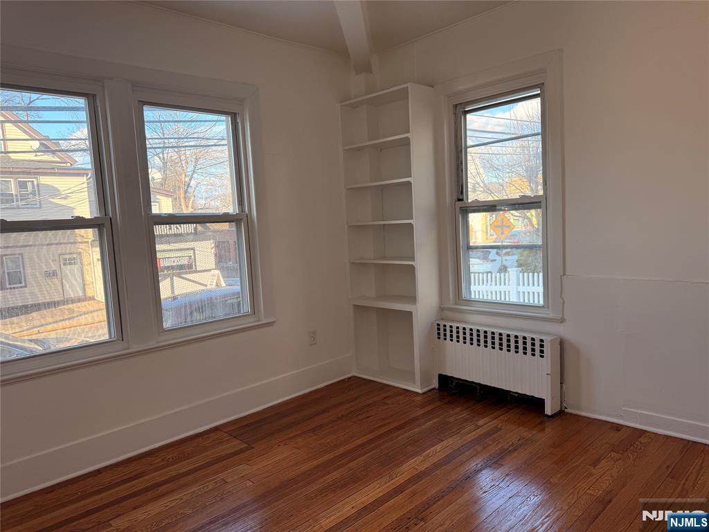 86 West Main Street, Unit FIRST Bergenfield, NJ 07621 - Photo 15 of 23 an empty room with wooden floor and windows