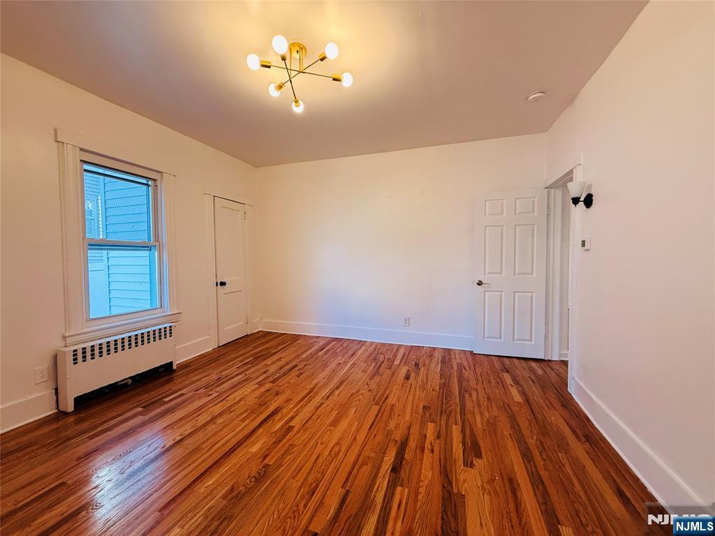 86 West Main Street, Unit FIRST Bergenfield, NJ 07621 - Photo 17 of 23 wooden floor in an empty room with a window