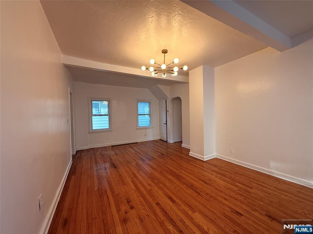86 West Main Street, Unit FIRST Bergenfield, NJ 07621 - Photo 3 of 23 wooden floor in an empty room with a window