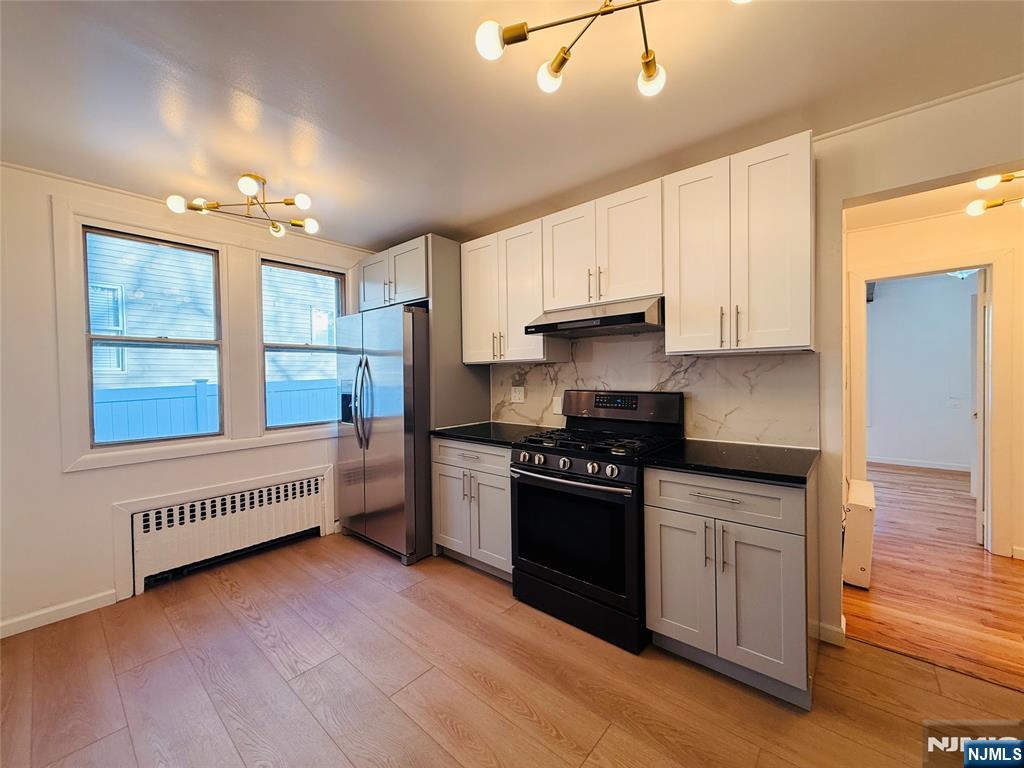 86 West Main Street, Unit FIRST Bergenfield, NJ 07621 - Photo 5 of 23 a kitchen with granite countertop a stove and a refrigerator