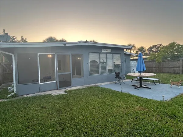 a view of a house with backyard sitting area and garden