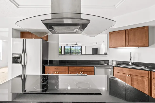 a kitchen with stainless steel appliances granite countertop a sink stove and refrigerator