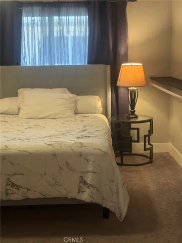 a bed sitting in a bedroom next to a window