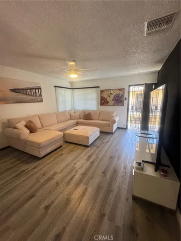 a living room with furniture and a wooden floor