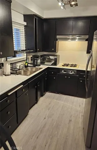 a kitchen with stainless steel appliances kitchen island granite countertop a sink dishwasher stove and cabinets