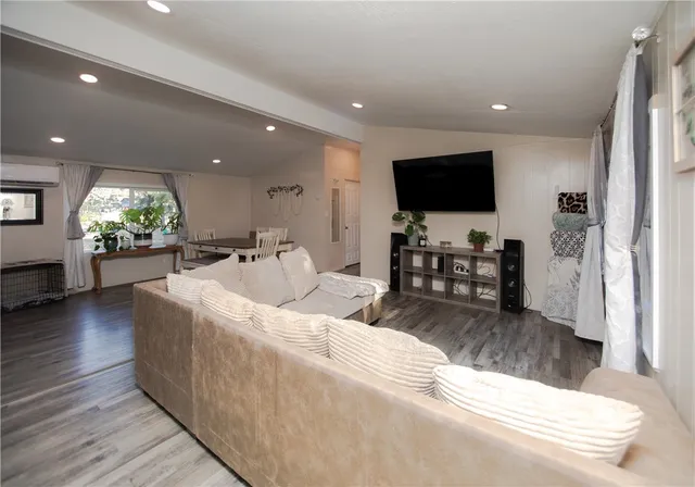 a kitchen with stainless steel appliances granite countertop a refrigerator a stove and white cabinets with wooden floor