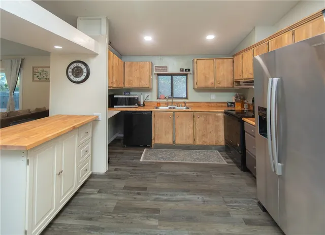 a large kitchen with a lot of counter space and wooden floor