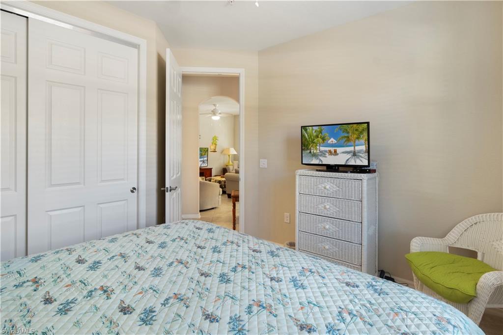 9063 Capistrano Street North, Unit 4405 Naples, FL 34113 - Photo 11 of 40 a bedroom with a bed and a dresser in it