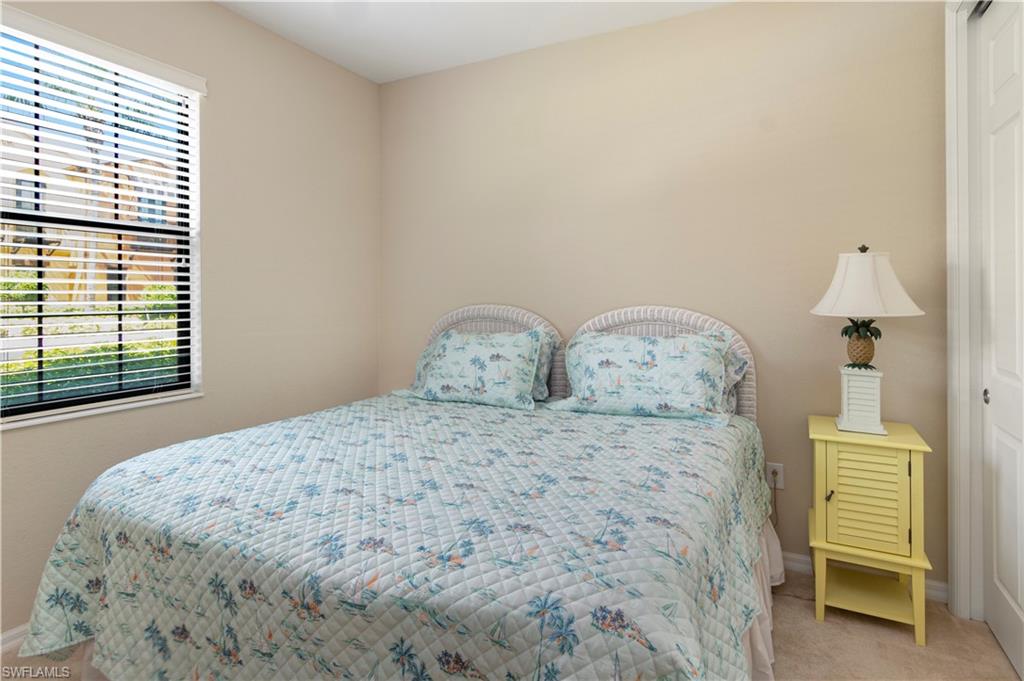 9063 Capistrano Street North, Unit 4405 Naples, FL 34113 - Photo 12 of 40 a bedroom with a bed and a chair