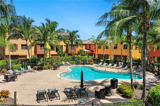 a row of palm trees and swimming pool in the backyard of a house