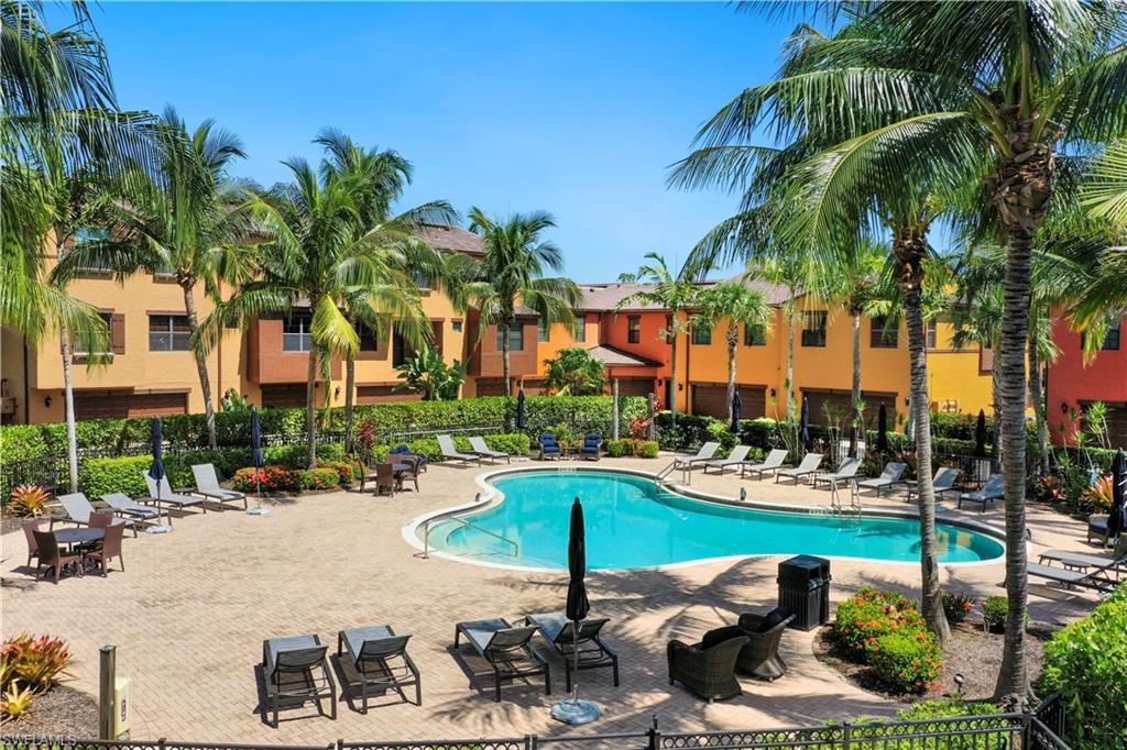 9063 Capistrano Street North, Unit 4405 Naples, FL 34113 - Photo 18 of 40 a row of palm trees and swimming pool in the backyard of a house