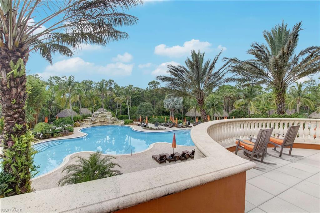 9063 Capistrano Street North, Unit 4405 Naples, FL 34113 - Photo 36 of 40 a view of a swimming pool with lounge chair and palm trees