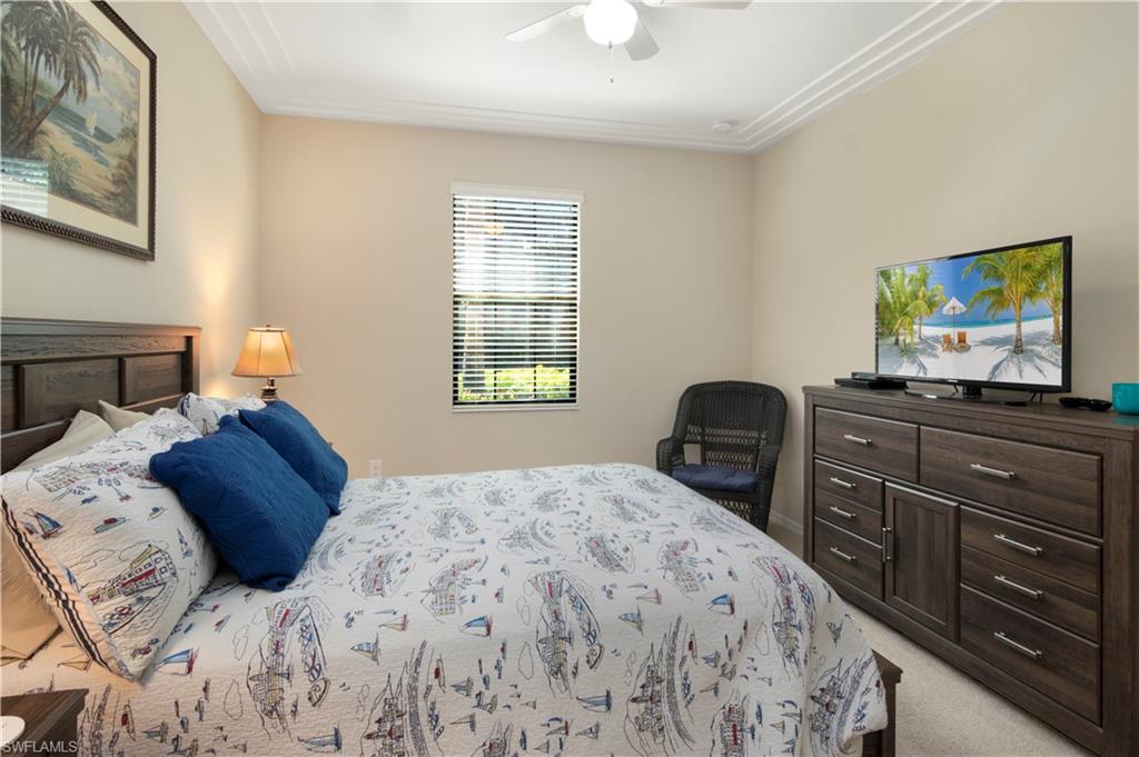 9063 Capistrano Street North, Unit 4405 Naples, FL 34113 - Photo 8 of 40 a bedroom with a bed and a dresser
