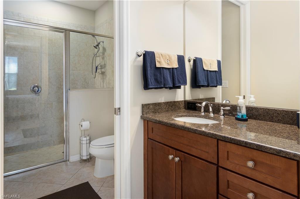 9063 Capistrano Street North, Unit 4405 Naples, FL 34113 - Photo 9 of 40 a bathroom with a granite countertop sink toilet and shower