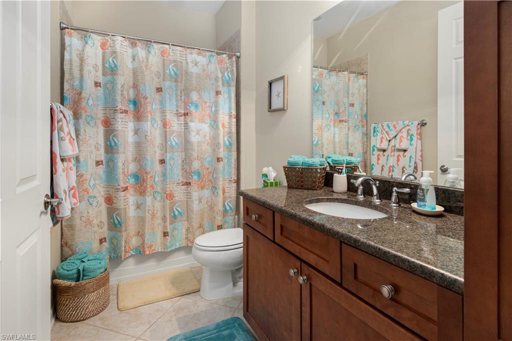 9063 Capistrano Street North, Unit 4405 Naples, FL 34113 - Photo 10 of 40 a spacious bathroom with a granite countertop sink and a mirror