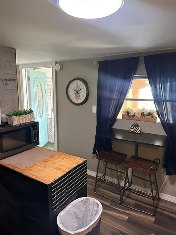 a kitchen with a table chairs a stove a window and dining table