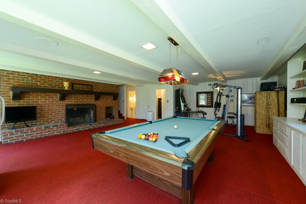 1410 Heathcliff Road High Point, NC 27262 - Photo 48 of 50 Vintage Rec Room Alert! The basement has a pool table that remains and wood burning fireplace. There is a full bath and a wet bar around the corner. Very dry storage room off of this room