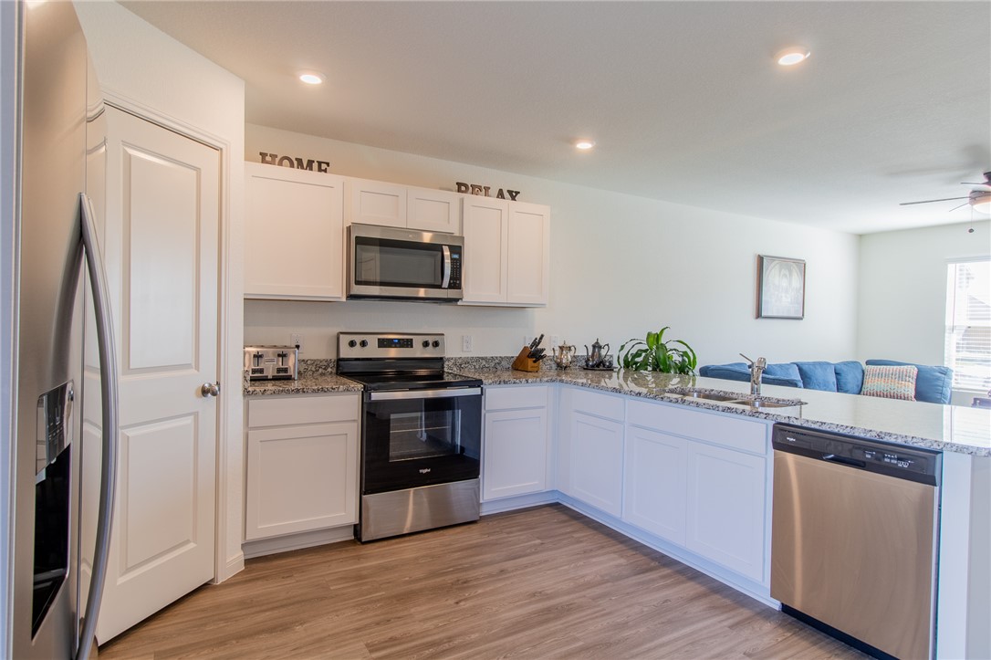 6029 Toby Bend Bryan, TX 77807 - Photo 4 of 25 a kitchen with granite countertop a refrigerator and a sink