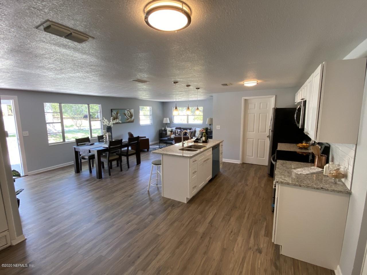 471 Sigsbee Road Orange Park, FL 32073 - Photo 4 of 17 a kitchen with a table chairs refrigerator and a wooden floor