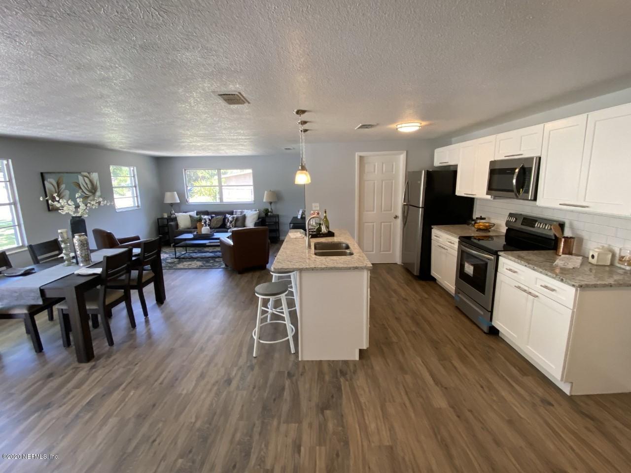 471 Sigsbee Road Orange Park, FL 32073 - Photo 6 of 17 a large open kitchen with a refrigerator a stove a dining table and chairs